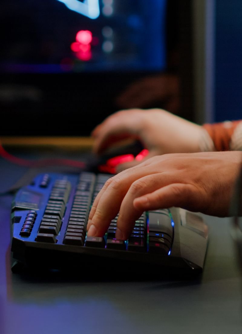 Close up of streamer typing at RGB keyboard playing space shooter videogame Close up of streamer typing at RGB keyboard playing space shooter videogame. Pro cyber man using mixer sound in gaming home studio for online esports competition on professional powerful computer